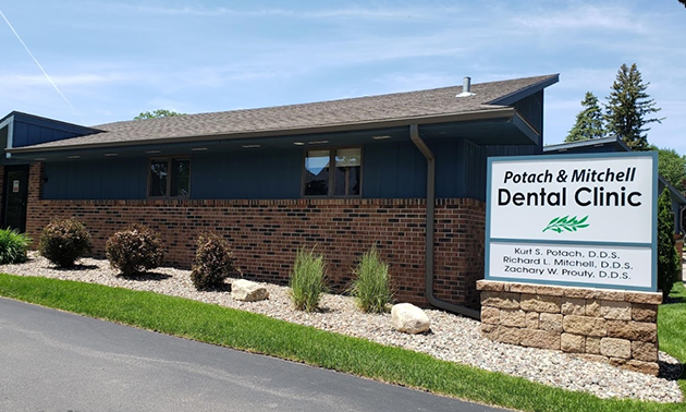 Potach & Mitchell Dental Clinic exterior with brick building, signage, landscaping, and driveway.