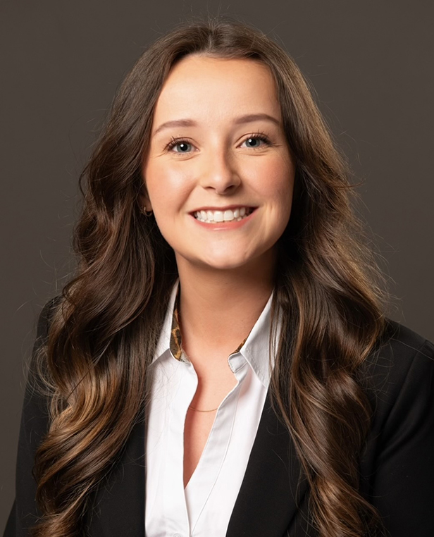 Professional headshot of woman in business attire smiling at dental clinic